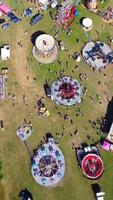 images aériennes de la fête foraine, les gens profitent de l'été chaud dans un parc public local de la ville de luton, une fête foraine a eu lieu avec des manèges effrayants pour les familles. video