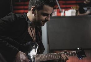 Cerca del hombre tocando la guitarra eléctrica durante el concierto foto