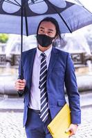 Cheerful Asian businessman in formal wear in the city photo