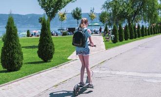 back view of a female riding electric scooter photo