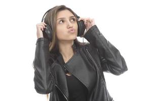 Beautiful modern girl singing favorite song, listening to music in wireless headphones, smiling and dancing photo