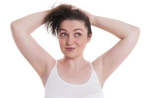 pretty young woman adjusting her hair before taking a shower. photo