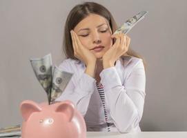 woman saving US Dollars in piggy bank photo