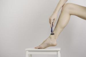 Woman shaving legs photo