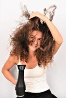 Portrait of beautiful cheerful girl with flying curly hair smiling laughing looking at camera over white background. photo