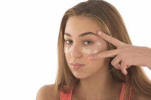 Close up of caucasian girl with natural no makeup look and white smile, take off silicone under eye patches and smiling happy, using skincare products from dark circles photo