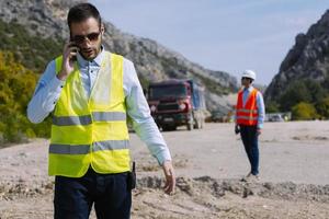 el ingeniero topógrafo está midiendo el nivel en el sitio de construcción. los topógrafos aseguran mediciones precisas antes de emprender grandes proyectos de construcción. foto