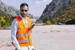 el ingeniero topógrafo está midiendo el nivel en el sitio de construcción. los topógrafos aseguran mediciones precisas antes de emprender grandes proyectos de construcción. foto