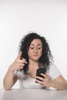 Portrait of a happy woman using mobile phone isolated over white background photo