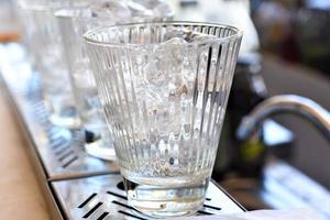 Glasses with ice cubes on wooden table photo