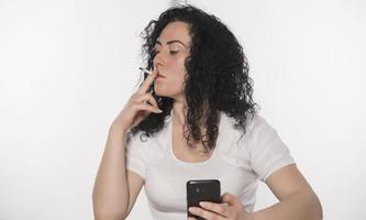 Portrait of a happy woman using mobile phone isolated over white background photo