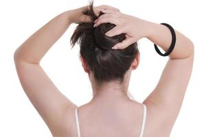 bastante joven ajustando su cabello antes de tomar una ducha. foto