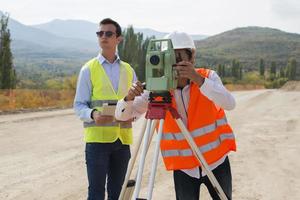 Surveyor engineer is measuring level on construction site. Surveyors ensure precise measurements before undertaking large construction projects. photo