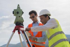 el ingeniero topógrafo está midiendo el nivel en el sitio de construcción. los topógrafos aseguran mediciones precisas antes de emprender grandes proyectos de construcción. foto