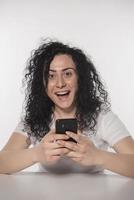 Portrait of a happy woman using mobile phone isolated over white background photo