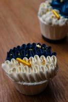 Luxurious and elegant cupcakes, with white cream and navy blue with gold sprinkles. photo