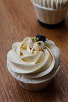 Luxurious and elegant cupcakes, with white cream and navy blue with gold sprinkles. photo