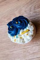 Luxurious and elegant cupcakes, with white cream and navy blue with gold sprinkles. photo