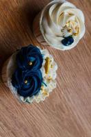 Luxurious and elegant cupcakes, with white cream and navy blue with gold sprinkles. photo