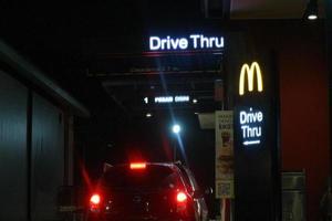 java occidental, indonesia en julio de 2022. brillante cartel del restaurante mcdonalds contra el cielo nocturno. logotipo de mcd drive thru. foto