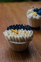 Luxurious and elegant cupcakes, with white cream and navy blue with gold sprinkles. photo