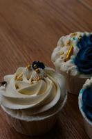 cupcakes lujosos y elegantes, con crema blanca y azul marino con chispas doradas. foto