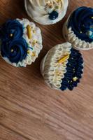 Luxurious and elegant cupcakes, with white cream and navy blue with gold sprinkles. photo