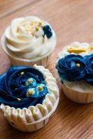 Luxurious and elegant cupcakes, with white cream and navy blue with gold sprinkles. photo