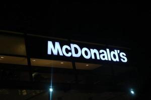 java occidental, indonesia en julio de 2022. brillante cartel del restaurante mcdonalds contra el cielo nocturno. logotipo de mcd drive thru. foto