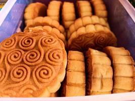 Mooncakes filled with red beans and green beans are arranged in a container photo