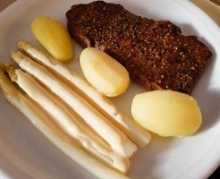 a freshly fried beef steak from the frying pan with delicious ingredients photo