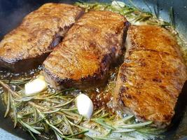 a freshly fried beef steak from the frying pan with delicious ingredients photo