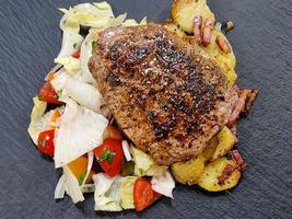 a freshly fried beef steak from the frying pan with delicious ingredients photo