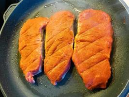 a freshly fried beef steak from the frying pan with delicious ingredients photo