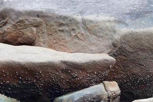 Close up view at a granite and stone wall texture in a high resolution. photo