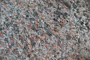 Close up view at a granite and stone wall texture in a high resolution. photo