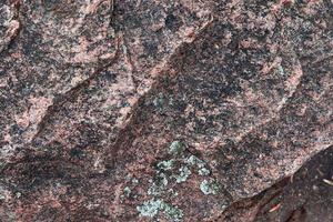 Close up view at a granite and stone wall texture in a high resolution. photo