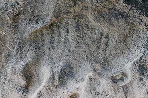 Close up view at a granite and stone wall texture in a high resolution. photo