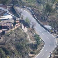 Aerial top view of traffic vehicles driving at mountains roads at Nainital, Uttarakhand, India, View from the top side of mountain for movement of traffic vehicles