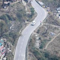 Aerial top view of traffic vehicles driving at mountains roads at Nainital, Uttarakhand, India, View from the top side of mountain for movement of traffic vehicles photo