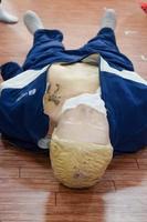 el maniquí humano yace en el suelo durante el entrenamiento de primeros auxilios - reanimación cardiopulmonar. curso de primeros auxilios en maniquí de cpr, concepto de capacitación en primeros auxilios de cpr foto