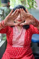 hermosa mujer vestida como tradición india con diseño de henna mehndi en ambas manos para celebrar el gran festival de karwa chauth, celebraciones de karwa chauth de una mujer india para su marido foto