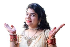 Beautiful woman dressed up as Indian tradition with henna mehndi design on her both hands to celebrate big festival of Karwa Chauth with plain white background photo