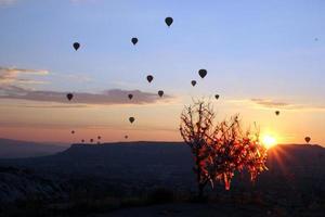 Travel to Goreme, Cappadocia, Turkey. The sunrise in the mountains with a lot of air hot balloons in the sky. photo