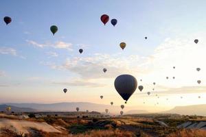 Travel to Goreme, Cappadocia, Turkey. The sunrise in the mountains with a lot of air hot balloons in the sky. photo