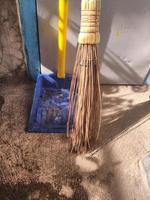 household utensils, broom and dustpan on floor in the house. Home cleaning equipment photo