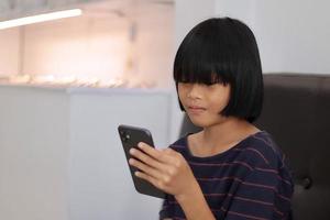 niño sentado al teléfono en casa foto