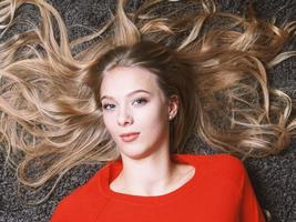 young woman with her long blond hair spread out photo