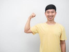 Asian man yellow shirt smiling show muscle copy space photo