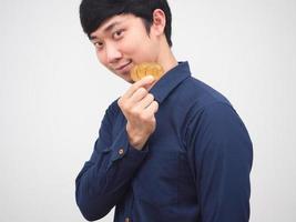 Portrait asian man smile and holding golden bitcoins in hand look confident face photo